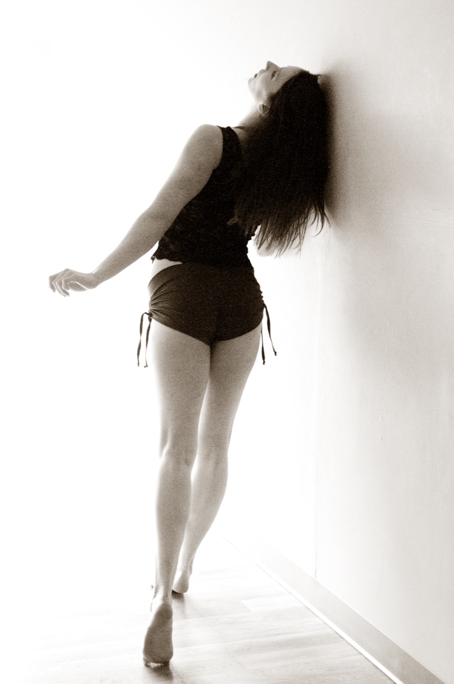 Hannah dancing on tiptoe beside a studio wall